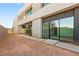 A modern home's backyard featuring pavers, a minimalist landscape, and expansive sliding glass doors at 25 Canyon Bay Dr, Henderson, NV 89011