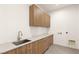 This laundry room features wood cabinets, a stainless steel sink and modern fixtures at 25 Canyon Bay Dr, Henderson, NV 89011