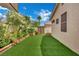 Lush backyard with artificial turf, blooming flowers, and a shady area for relaxation and outdoor enjoyment at 2558 Wiltshire Ave, Henderson, NV 89052