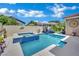 Backyard oasis features a sparkling pool, a hot tub, and ample lounging space under a sunny blue sky at 2558 Wiltshire Ave, Henderson, NV 89052
