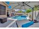 Inviting backyard features a shimmering pool and spa, complemented by comfortable lounge area and shaded dining space at 2558 Wiltshire Ave, Henderson, NV 89052