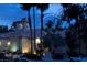 Community building with Spanish-style architecture, mature trees, and parking at dusk at 270 E Flamingo Rd # 131, Las Vegas, NV 89169