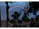 Exterior shot of Ferris wheel with palm trees and roof tile in foreground at night at 270 E Flamingo Rd # 131, Las Vegas, NV 89169