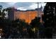 Distant view of the Cosmopolitan Hotel behind lush community landscaping and trees at 270 E Flamingo Rd # 131, Las Vegas, NV 89169