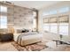 Comfortable bedroom featuring a stylish accent wall, large windows, and a cozy rug at 300 Talon Heights St, Las Vegas, NV 89138