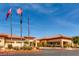 A clubhouse with beautiful landscaping under a bright blue sky with the American flag at 3124 Kookaburra Way, North Las Vegas, NV 89084