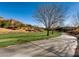 Community green space with a sidewalk path through an open lawn area and sparse trees at 3124 Kookaburra Way, North Las Vegas, NV 89084