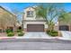 Traditional home with a two-car garage, complemented by mature trees and manicured shrubs at 3712 Gilmore Creek St, Las Vegas, NV 89129