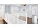 Bright hallway features hardwood floors, white railing, and a ceiling fan at 3712 Gilmore Creek St, Las Vegas, NV 89129