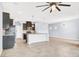 Modern kitchen open to living area boasts granite counters, tile floors, and stainless appliances at 3712 Gilmore Creek St, Las Vegas, NV 89129