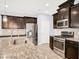 Well-equipped kitchen with stainless steel appliances, granite countertops, and tile backsplash, offering both style and functionality at 3712 Gilmore Creek St, Las Vegas, NV 89129