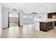 Open-concept living area featuring tile flooring, a modern light fixture, and a sliding glass door leading to the backyard at 3712 Gilmore Creek St, Las Vegas, NV 89129