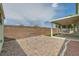 A spacious backyard featuring desert landscaping, a brick wall, and covered patio area at 4318 Scarlet Vista Ct, North Las Vegas, NV 89031