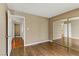 Empty bedroom features a mirrored closet, hardwood floors, and tan colored walls at 4391 Gannet Cir # 16, Las Vegas, NV 89103