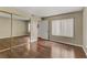 Bedroom features a mirrored closet, hardwood floors, and a window at 4391 Gannet Cir # 16, Las Vegas, NV 89103