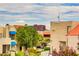 Condo complex exterior with address sign, manicured landscaping, and Las Vegas hotels in the distance at 4391 Gannet Cir # 16, Las Vegas, NV 89103