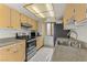 Kitchen with stainless steel appliances, tile flooring, and wood cabinets at 4391 Gannet Cir # 16, Las Vegas, NV 89103