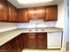 Kitchen featuring dark wood cabinets, stainless steel sink, and white dishwasher at 4421 Alexis Dr # 429, Las Vegas, NV 89103