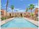Community pool surrounded by palm trees and multi-story building at 4421 Alexis Dr # 429, Las Vegas, NV 89103