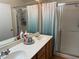 Bathroom showcasing a double sink vanity, large mirror, and a glass-enclosed shower with a curtain at 4833 Lawnwood Ct, Las Vegas, NV 89130