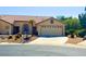 Charming single-story home featuring a two-car garage, desert landscaping, and a well-manicured lawn at 4833 Lawnwood Ct, Las Vegas, NV 89130