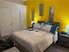 Well-lit Main Bedroom with a bed, side tables and bright yellow walls at 4833 Lawnwood Ct, Las Vegas, NV 89130