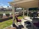 Relaxing covered patio with seating, a fire pit, and views of the manicured lawn, ideal for outdoor gatherings at 4833 Lawnwood Ct, Las Vegas, NV 89130