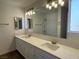 Bathroom with double sinks, vanity, and a large mirror with stylish lighting fixtures at 5030 Salinaz Cir, Las Vegas, NV 89118