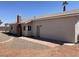 Tan single-story house featuring a brick chimney and walkway along the side at 5030 Salinaz Cir, Las Vegas, NV 89118