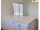 Bright kitchen featuring white cabinets, quartz countertops, and sliding glass doors to the backyard at 5030 Salinaz Cir, Las Vegas, NV 89118