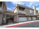 Beige townhome exterior with multiple garage doors, balcony, and well-maintained landscaping at 5125 W Reno Ave # 1059, Las Vegas, NV 89118