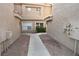 Walkway between buildings with views of stucco walls, and well-kept gravel and landscaping at 5125 W Reno Ave # 1059, Las Vegas, NV 89118