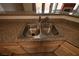 Stainless steel sink with granite counters and wooden cabinets below at 5125 W Reno Ave # 1059, Las Vegas, NV 89118