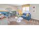 Bright living room features a blue sofa, modern decor, and a window offering natural light and neighborhood views at 551 Ruby Robin Ave # Lot 750, Henderson, NV 89011