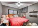 Bedroom with gray walls, fan, and decorative shelving, with a red comforter on the bed at 5900 Fawn Ave, Las Vegas, NV 89107