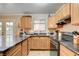Kitchen featuring wooden cabinets, black countertops, and stainless steel appliances at 5900 Fawn Ave, Las Vegas, NV 89107