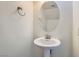 Bathroom with oval mirror and pedestal sink at 5947 Wellington Peak Rd, Las Vegas, NV 89148