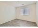 This bedroom features neutral paint, light-colored floors, and a window with blinds at 5947 Wellington Peak Rd, Las Vegas, NV 89148