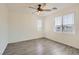 Sunlit bedroom with two windows, a ceiling fan, and wood-look flooring at 5947 Wellington Peak Rd, Las Vegas, NV 89148