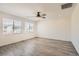 Spacious bedroom featuring wood-look floors, a ceiling fan, and ample natural light at 5947 Wellington Peak Rd, Las Vegas, NV 89148