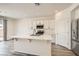 Bright, open kitchen with white cabinets, an island, and a sliding glass door at 5947 Wellington Peak Rd, Las Vegas, NV 89148