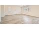 Spacious living area with wood-look floors and a wall of windows at 5947 Wellington Peak Rd, Las Vegas, NV 89148
