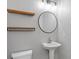 This modern bathroom features floating shelves, a round mirror, and a pedestal sink at 644 Wind Cave Ct, Henderson, NV 89012