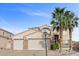 Inviting two-story home with a three-car garage, desert landscaping, and mature palm trees at 644 Wind Cave Ct, Henderson, NV 89012