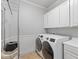 A well-organized laundry room with modern washer, dryer and ample storage cabinets at 644 Wind Cave Ct, Henderson, NV 89012