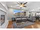 Spacious living room with fireplace, hardwood floors, and gray sectional sofa at 644 Wind Cave Ct, Henderson, NV 89012
