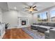 Living room with a gray sofa set, wood flooring, and natural light from the large windows at 644 Wind Cave Ct, Henderson, NV 89012