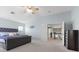 Spacious main bedroom featuring a large bed, neutral carpet, and access to the upper floor at 644 Wind Cave Ct, Henderson, NV 89012