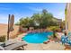 Inviting backyard oasis with a private pool, rock waterfall, mature trees and an umbrella for lounging at 644 Wind Cave Ct, Henderson, NV 89012