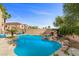 Sparkling pool and rock waterfall feature create a private backyard escape perfect for relaxation and outdoor fun at 644 Wind Cave Ct, Henderson, NV 89012
